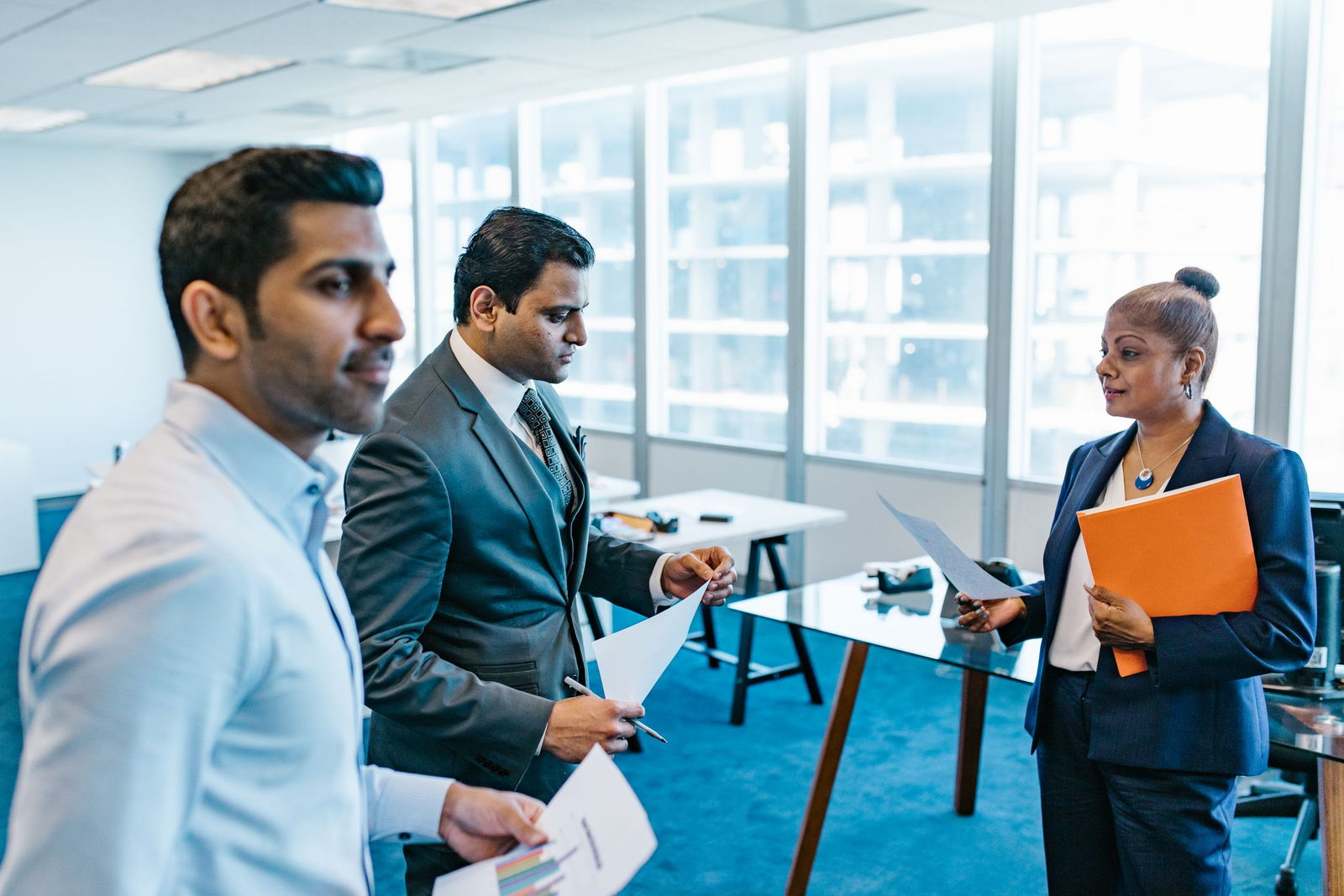 Colleagues reviewing hiring documents together in a bright office